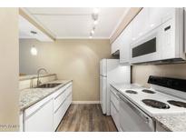 Well-lit kitchen with white cabinetry, modern appliances, and granite countertops at 3314 N 68Th St # W112, Scottsdale, AZ 85251