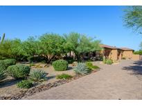 Stunning desert landscaping enhances this home's curb appeal, set against a clear blue sky at 35443 N 87Th Pl, Scottsdale, AZ 85266