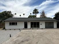 Charming single-story home with a gray roof and well-manicured landscaping at 3933 E Flower St, Phoenix, AZ 85018