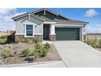 Charming single-story home features desert landscaping, a two-car garage and covered entryway at 42440 W Peters Dr, Maricopa, AZ 85138