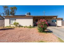 Charming single story home with a covered porch and colorful front yard plants at 4403 N 56Th Dr, Phoenix, AZ 85031