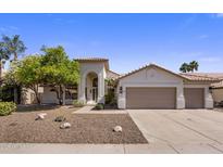 Charming single-story home featuring a well-manicured yard, desert landscaping, and a three-car garage at 5520 E Muriel Dr, Scottsdale, AZ 85254