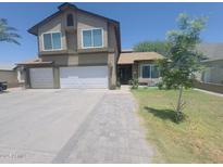 Charming two-story home with a three-car garage, a walkway, and a well-manicured lawn at 8742 W Edgemont Ave, Phoenix, AZ 85037