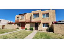 A charming townhome featuring a stucco exterior, small balconies, and well-maintained landscaping at 948 S Alma School Rd # 71, Mesa, AZ 85210