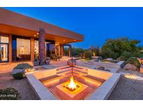 Inviting outdoor space featuring a modern fire pit, seating, and desert landscaping, perfect for evening relaxation and entertainment at 10267 E Cinder Cone Trl, Scottsdale, AZ 85262