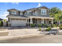 Charming two-story home features a well-manicured lawn, gray paint, and a spacious two car garage at 10353 E Trillium Ave, Mesa, AZ 85212