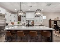 A spacious kitchen boasts white cabinets, a large center island, and pendant lighting above the breakfast bar at 11385 N Luckenbach St, Surprise, AZ 85388