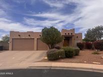 Charming single-story home with a three-car garage and desert landscaping under a partly cloudy blue sky at 1428 N Leandro Cir, Mesa, AZ 85207