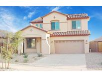 Charming two-story home features a tile roof, desert landscaping, and a two-car garage at 15241 W Madison St, Goodyear, AZ 85338