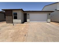 Newly constructed single Gathering home with a two car garage and a brick-accented exterior at 18168 W Larkspur Dr, Goodyear, AZ 85338