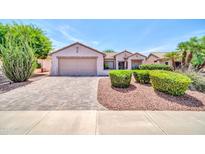 Charming single-story home with manicured landscaping, a two-car garage and a brick-paved driveway at 20215 N Mariposa Way, Surprise, AZ 85374