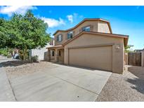 Charming two-story home with desert landscaping, two car garage, and a beautiful green tree in the front yard at 2327 E Meadow Creek Way, San Tan Valley, AZ 85140