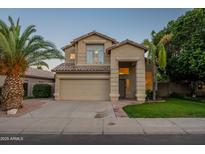 Charming two-story home boasts a well-manicured lawn, mature palm trees and a covered entryway at 2421 W Indigo Dr, Chandler, AZ 85248