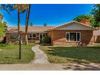 Charming brick home features a tile roof, green lawn, mature trees, and inviting walkway at 28 E 14Th St, Tempe, AZ 85281