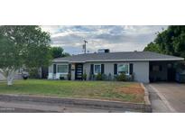 Charming single-story home with a well-maintained front yard, modern door, and a covered parking area at 3526 E Piccadilly Rd, Phoenix, AZ 85018