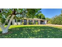 Inviting home featuring a lush green lawn and a modern front door at 3526 E Piccadilly Rd, Phoenix, AZ 85018