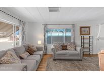 Bright living room features laminate flooring, neutral paint, and comfortable seating at 4065 E University Dr # 332, Mesa, AZ 85205