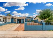 Charming blue single-story home with a well-kept front yard and black iron fence at 4219 W Pasadena Ave, Phoenix, AZ 85019