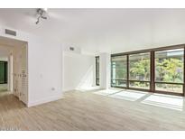 Bright living room with floor-to-ceiling windows and wood-style tile flooring at 4808 N 24Th St # 230, Phoenix, AZ 85016