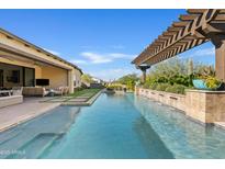 Inviting backyard pool with pergola, water feature, and lush desert landscaping for relaxation and outdoor enjoyment at 5420 E Duane Ln, Cave Creek, AZ 85331
