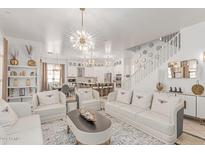 Bright living room with white sofas, chairs, a decorative rug, and a statement chandelier at 84 E Joseph Way, Gilbert, AZ 85295