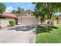 Charming single-story home with a two-car garage, a low maintenance yard and a well-kept lawn at 912 W Sunward Dr, Gilbert, AZ 85233