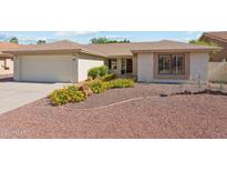 Charming single story home with a well-maintained front yard and attached two car garage at 9801 W Rockwood Dr, Peoria, AZ 85382