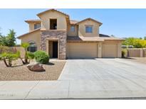 Two-story home with a three-car garage, stone accents, and manicured landscaping at 11048 E Quintana Ave, Mesa, AZ 85212