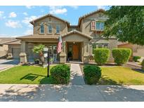 Charming two-story home with a landscaped front yard, inviting porch, and American flag at 14364 W Cameron Dr, Surprise, AZ 85379