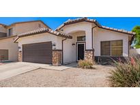 Charming single-story home featuring a brown garage door and decorative stone accents at 3528 W Paseo Way, Laveen, AZ 85339