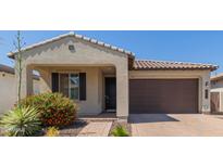 Charming single-story home featuring a tile roof, brick driveway, and tidy landscaping with red flowering shrubs at 3892 E Harrison St, Gilbert, AZ 85295