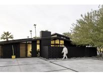 Striking modern home with sleek, dark exterior, complemented by desert landscaping and a minimalist design at 4032 N 45Th Pl, Phoenix, AZ 85018