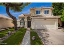 Inviting two-story home featuring a well-manicured lawn, desert landscaping, and a two-car garage at 4434 E Bannock St, Phoenix, AZ 85044