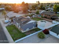 Lovely aerial view of home featuring a large backyard swimming pool and a well-manicured lawn at sunset at 4644 W Berridge Ln, Glendale, AZ 85301
