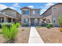 Charming two-story home featuring neutral paint, desert landscaping, and inviting front porch entry at 5741 W Warner St, Phoenix, AZ 85043