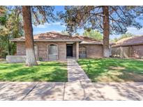 Charming brick home with mature trees and a well-manicured lawn at 917 E Lexington Ave, Gilbert, AZ 85234