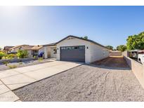 Charming single story home featuring a low maintenance yard, long driveway, and a gray color scheme at 9310 W Washington St, Tolleson, AZ 85353