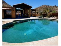 Stunning pool with desert landscape and outdoor covered seating area perfect for entertaining and relaxation at 9607 E Mckellips Rd, Mesa, AZ 85207