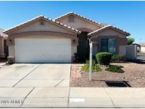 Charming single-story home featuring a two-car garage and well-maintained front yard landscaping at 10465 W Windsor Blvd, Glendale, AZ 85307