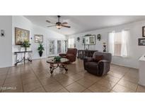 Bright living room with tile flooring, ceiling fan, comfortable seating, and lots of natural light at 10465 W Windsor Blvd, Glendale, AZ 85307