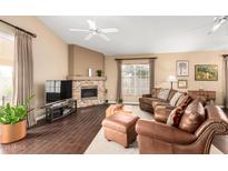 Cozy living room with a stone fireplace, leather furniture, and large window at 11807 E Clinton St, Scottsdale, AZ 85259