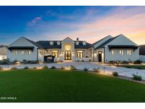 Stunning exterior elevation of a home with a well-manicured lawn and elegant facade at twilight at 12240 N 98Th St, Scottsdale, AZ 85260