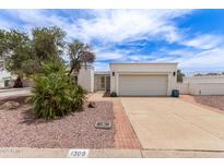 Charming single-story home with mature landscaping, two-car garage, and wrought iron security gate at 1309 E Meadow Ln, Phoenix, AZ 85022