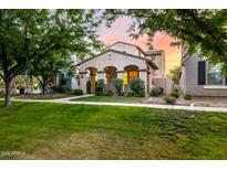Charming home boasts desert landscaping, covered porch, and warm exterior lighting at 15469 W Dreyfus St, Surprise, AZ 85379