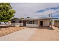 Inviting single-story home features a low-maintenance desert landscape, covered parking, and a charming white brick facade at 1654 E 2Nd St, Mesa, AZ 85203