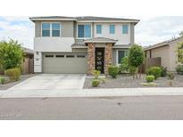 Charming two-story home with a stone-accented entryway, landscaped front yard, and attached two-car garage at 18813 W Solano Dr, Litchfield Park, AZ 85340