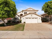 Charming two-story home featuring a well-maintained lawn, mature trees, and a spacious two-car garage at 20404 N 28Th Pl, Phoenix, AZ 85050
