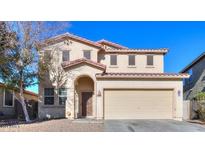 Charming two-story home with a red tile roof, arched entryway and a two car garage at 42468 W Palmyra Ct, Maricopa, AZ 85138