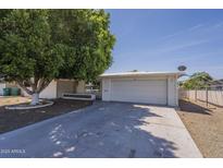 Charming single-story home features a well-maintained front yard with mature trees and a two-car garage at 5657 E Dallas St, Mesa, AZ 85205