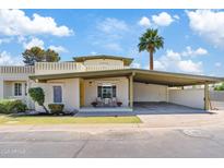 Charming single-level home with a covered carport, landscaped yard, and a sunny yellow door at 6001 N 10Th Way, Phoenix, AZ 85014